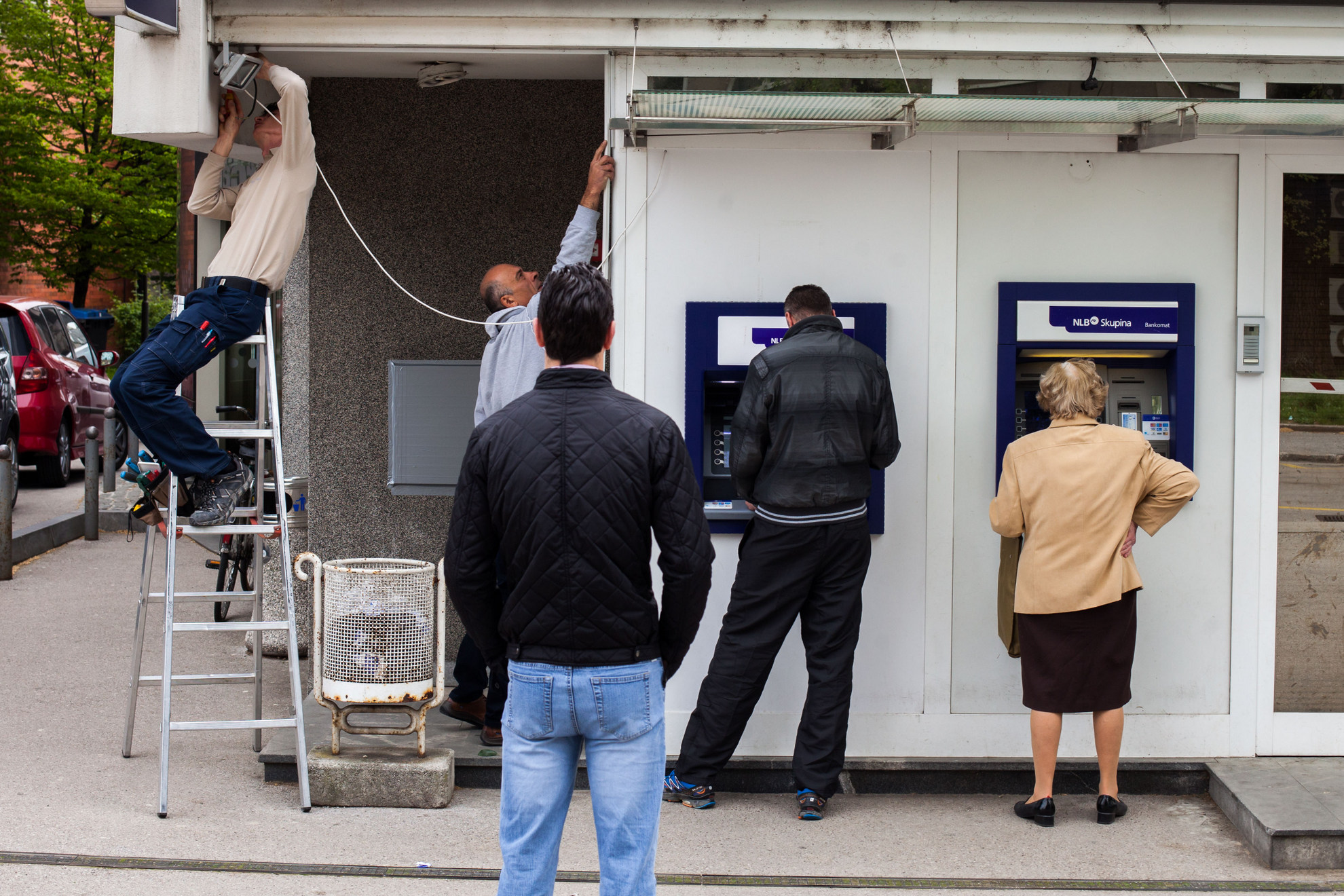 18. 04. 2016 Ljubljana socialna mobilnost. Ljudje čakajo pred bankomatom, medtem ko delavca delata.